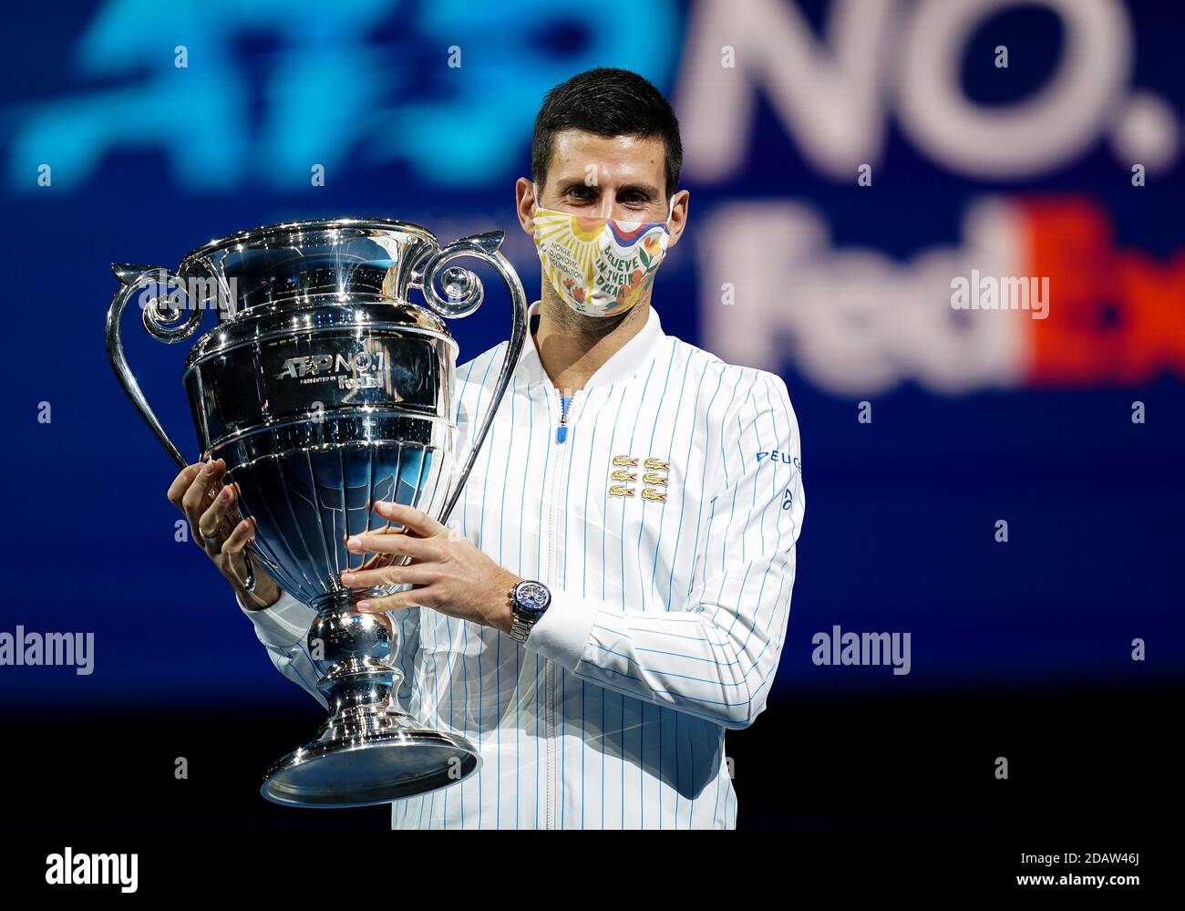 Novak Djokovic poses with his year end ATP number one trophy during day
