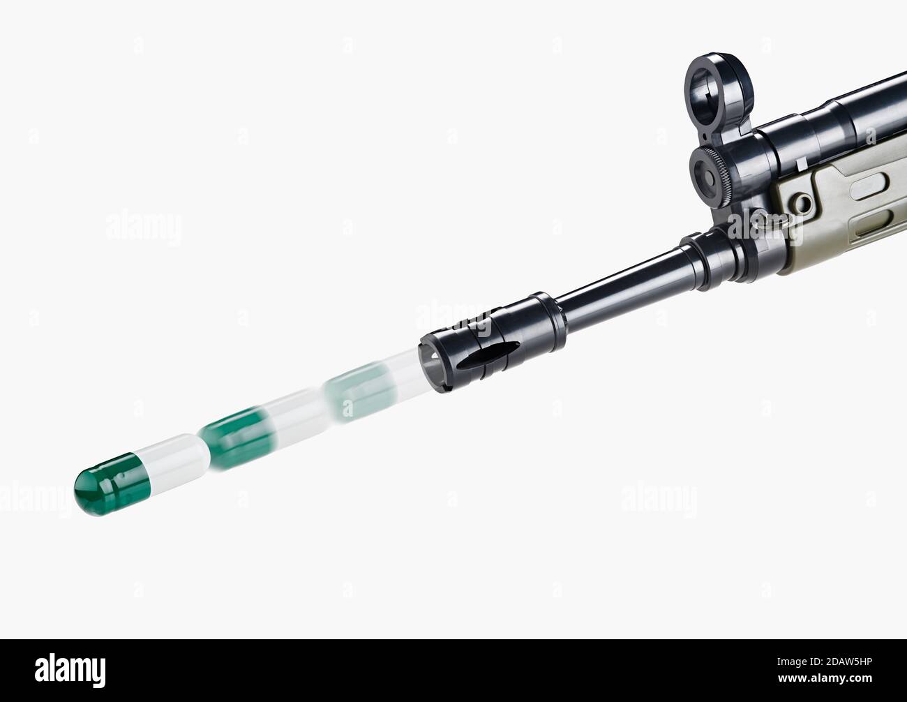 A shotgun shoots green and white medicine pills. Stock Photo