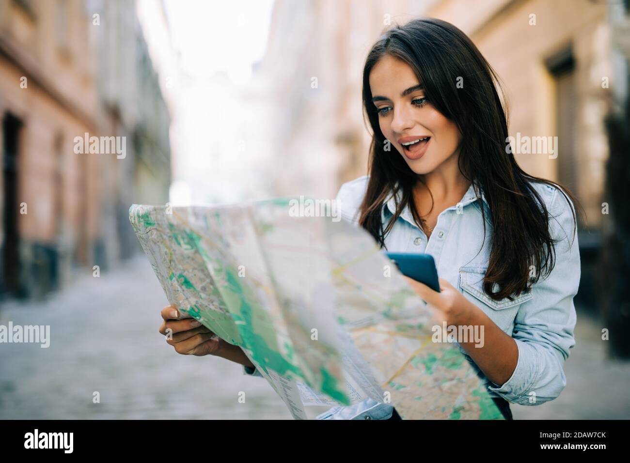Young traveller woman planning trip with map and smartphone Stock Photo ...