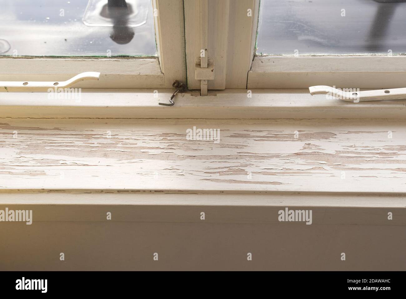 Old wooden window sill with cracked peeling paint and durt, needs renovation and repaired