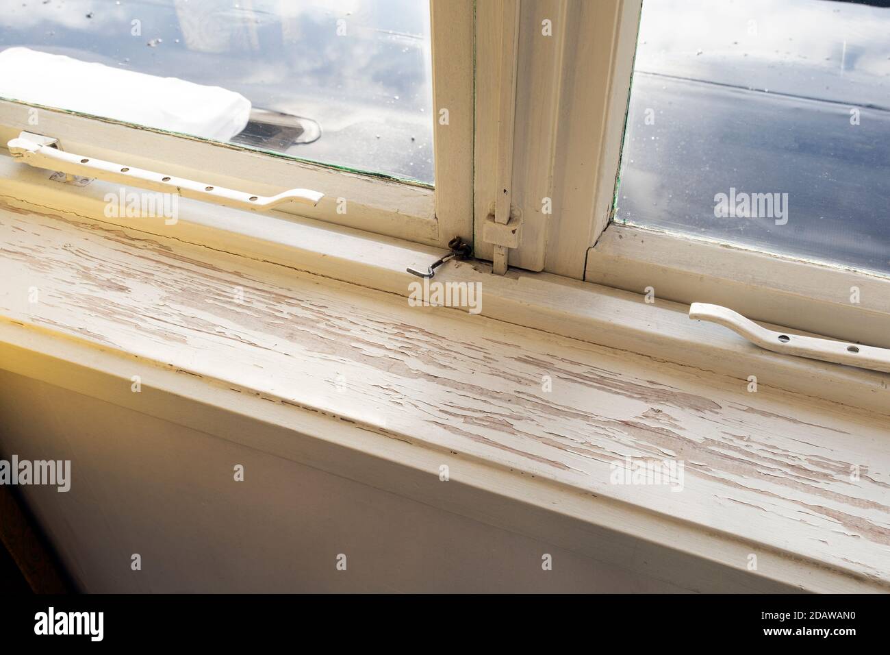 Old wooden window sill with cracked peeling paint and durt, needs renovation and repaired