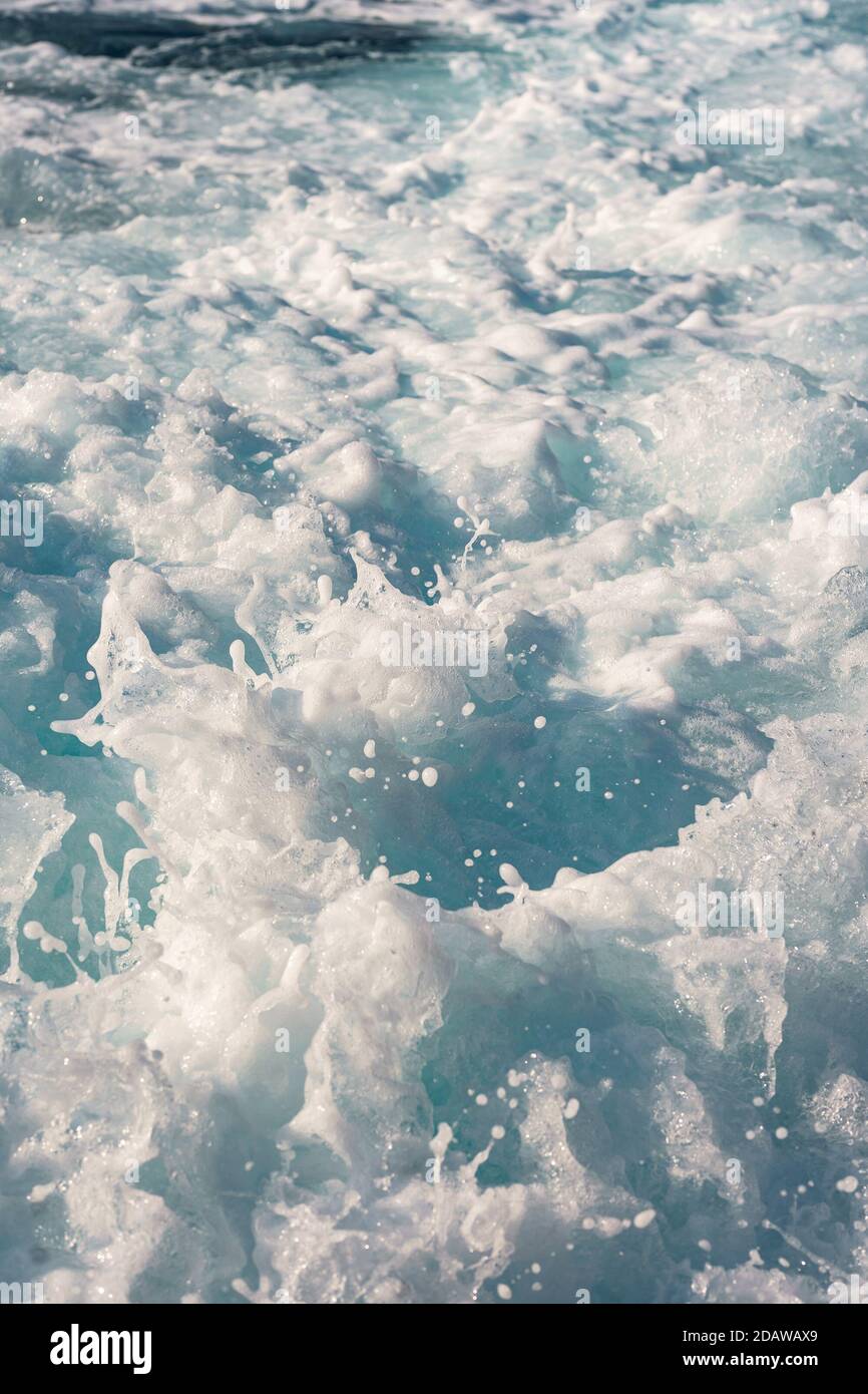 Water surface background. Blue sea water splashes with sun reflections. Ripples of water in the. Stock Photo