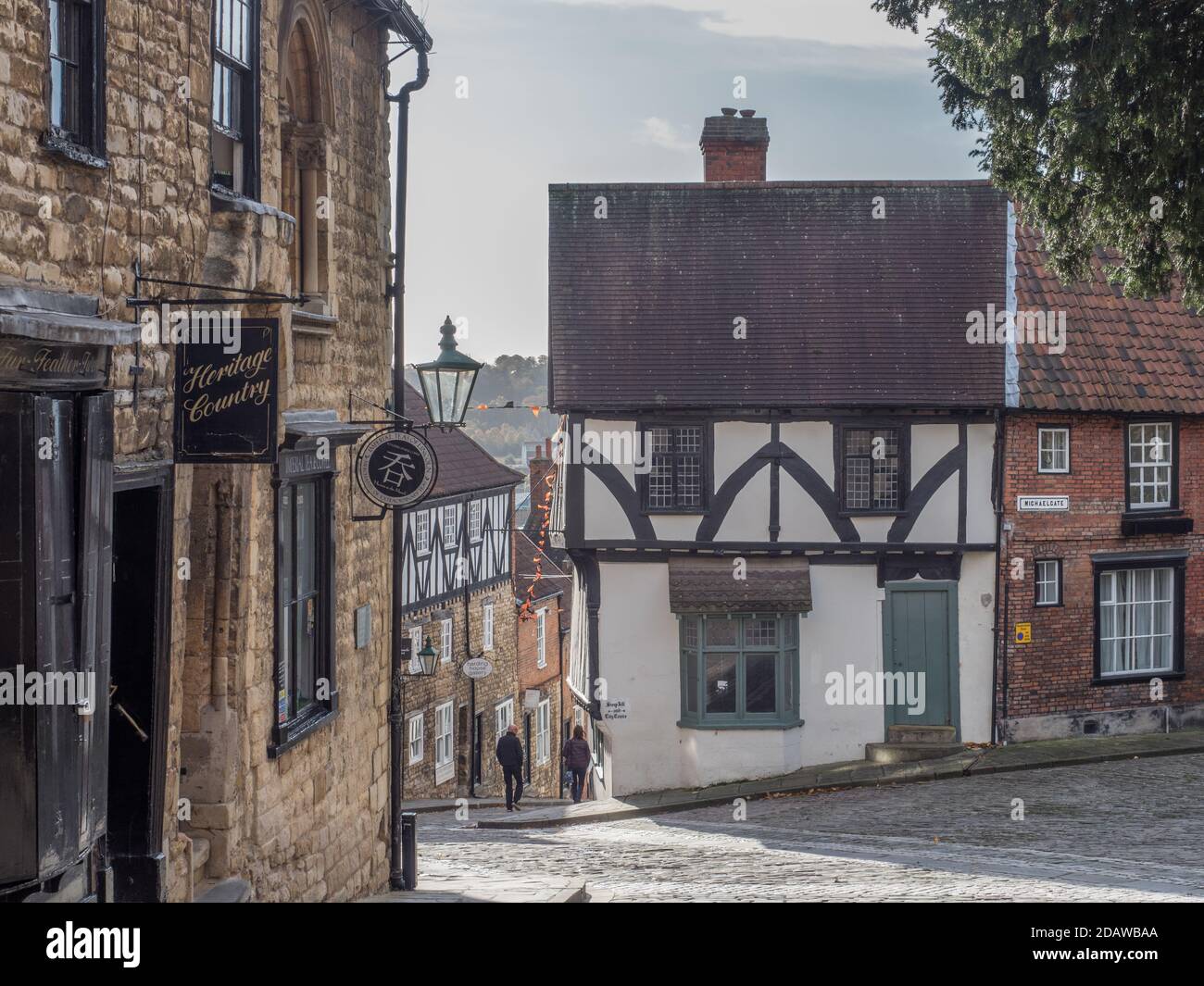 Looking down LIncoln's Steep Hill, a medieval old city touristic attraction on quiet day with 2 people Stock Photo