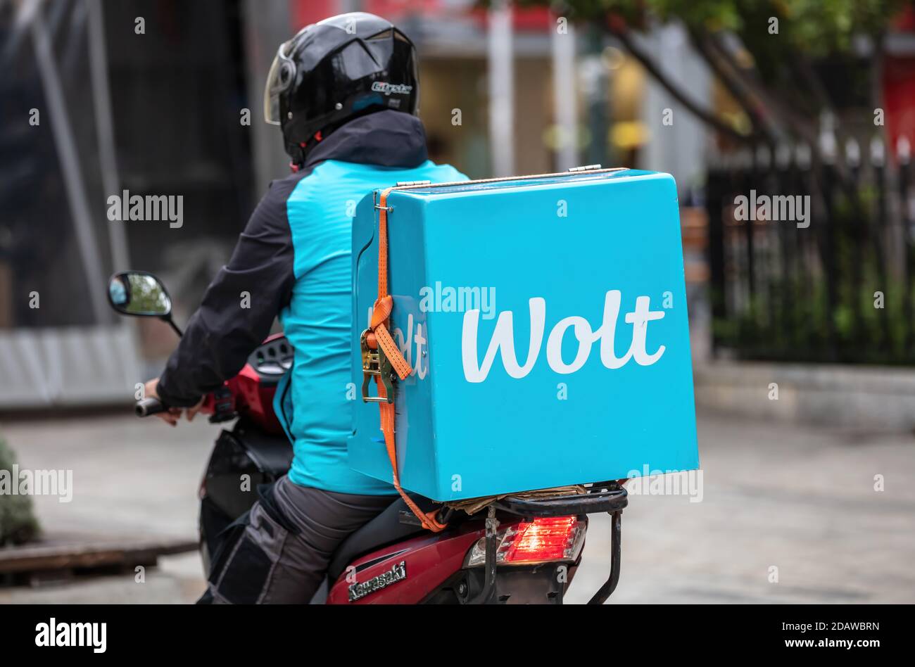 Athens, Greece. November 12, 2020. Wolt food delivery service, courier riding a scooter in the city center street, rear view Stock Photo