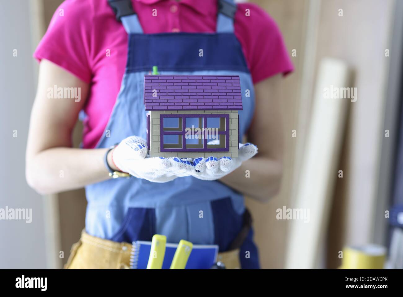 Builder holds the house in his hands. Stock Photo