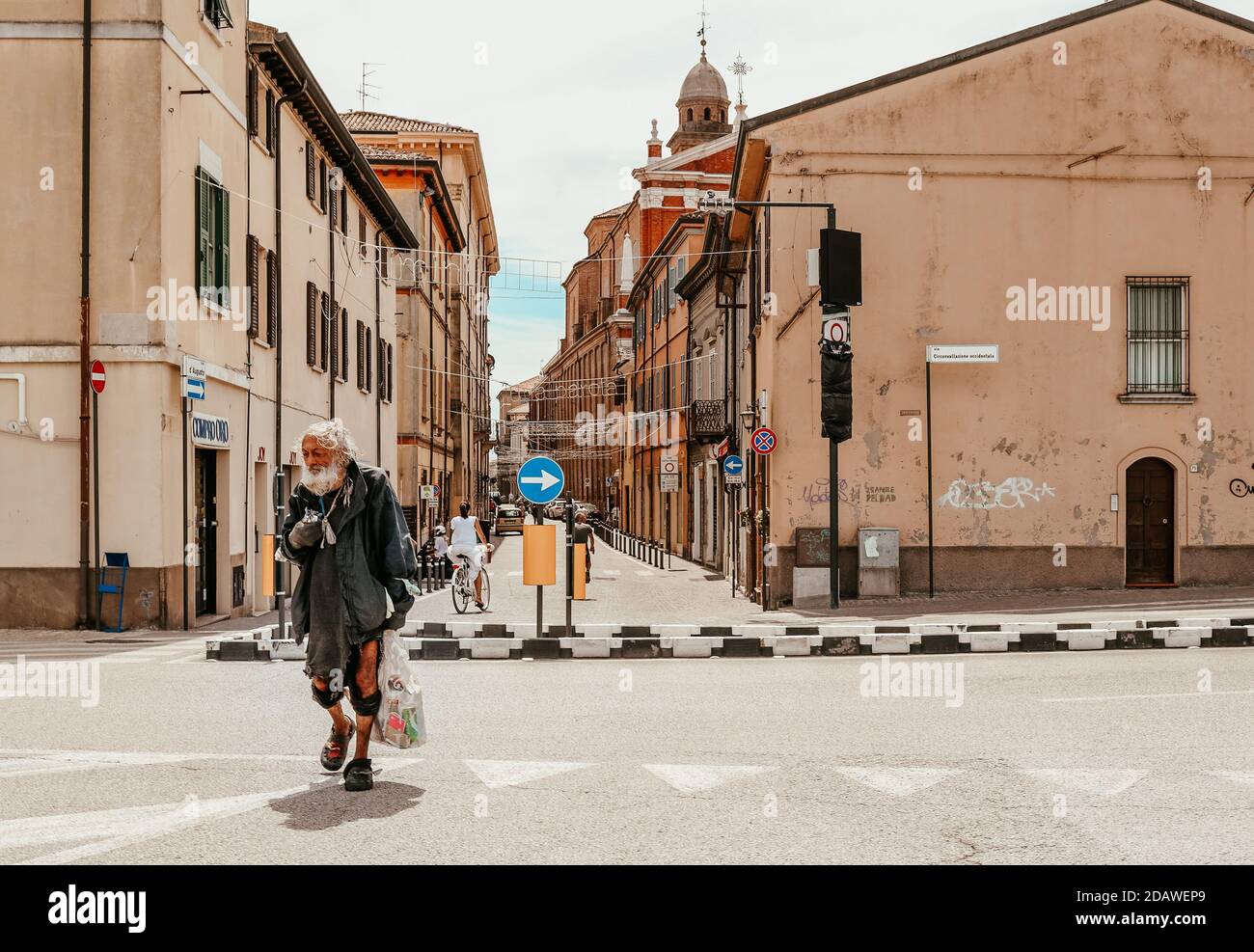 A homeless man walks down the street in Italy Stock Photo