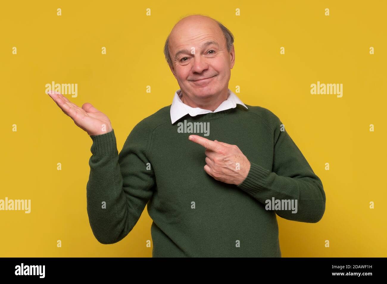 Confident hispanic senior smiling man point aside Stock Photo