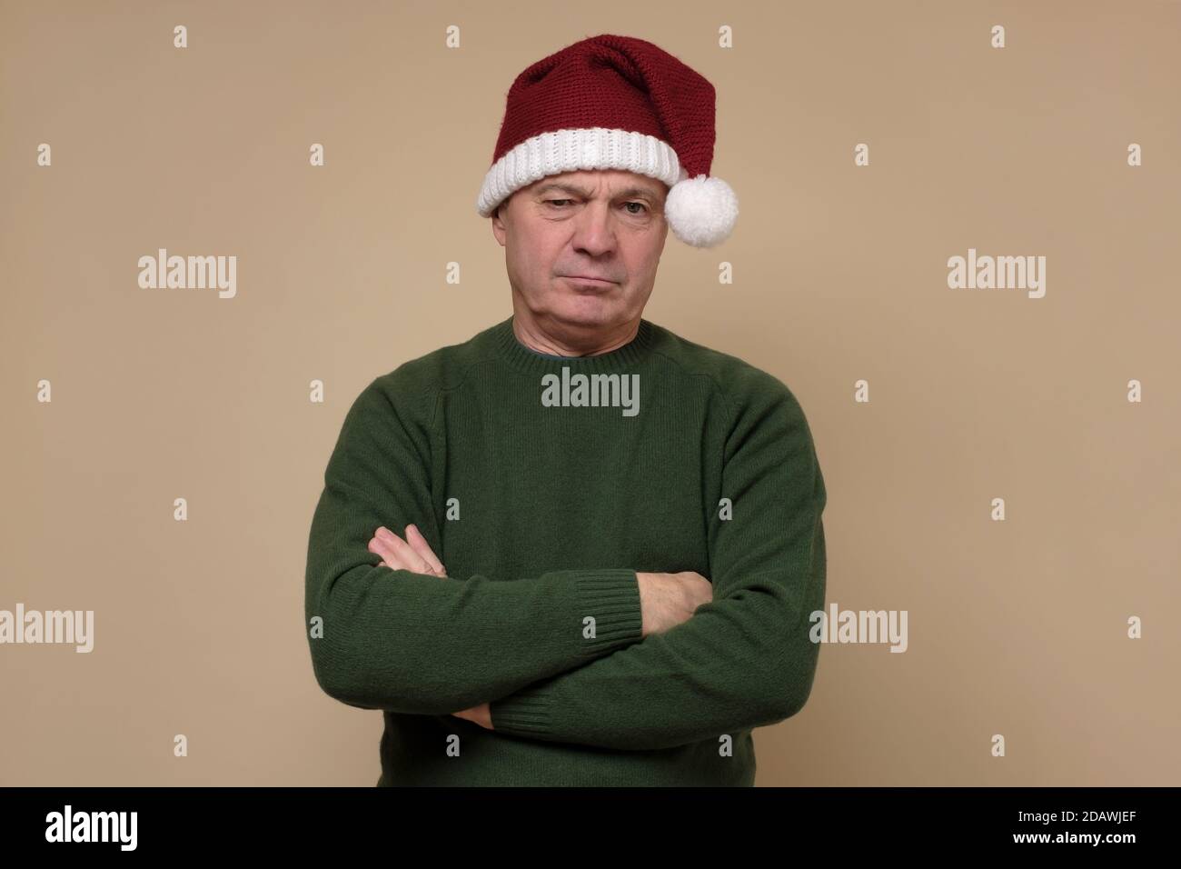 Sad senior man in santa hat looking angry. Stock Photo