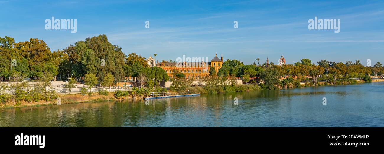 Historical Palacio de San Telmo in Baroque architecture on the green embankment of Guadalquivir river in Seville, Andalusia, Spain, panorama Stock Photo