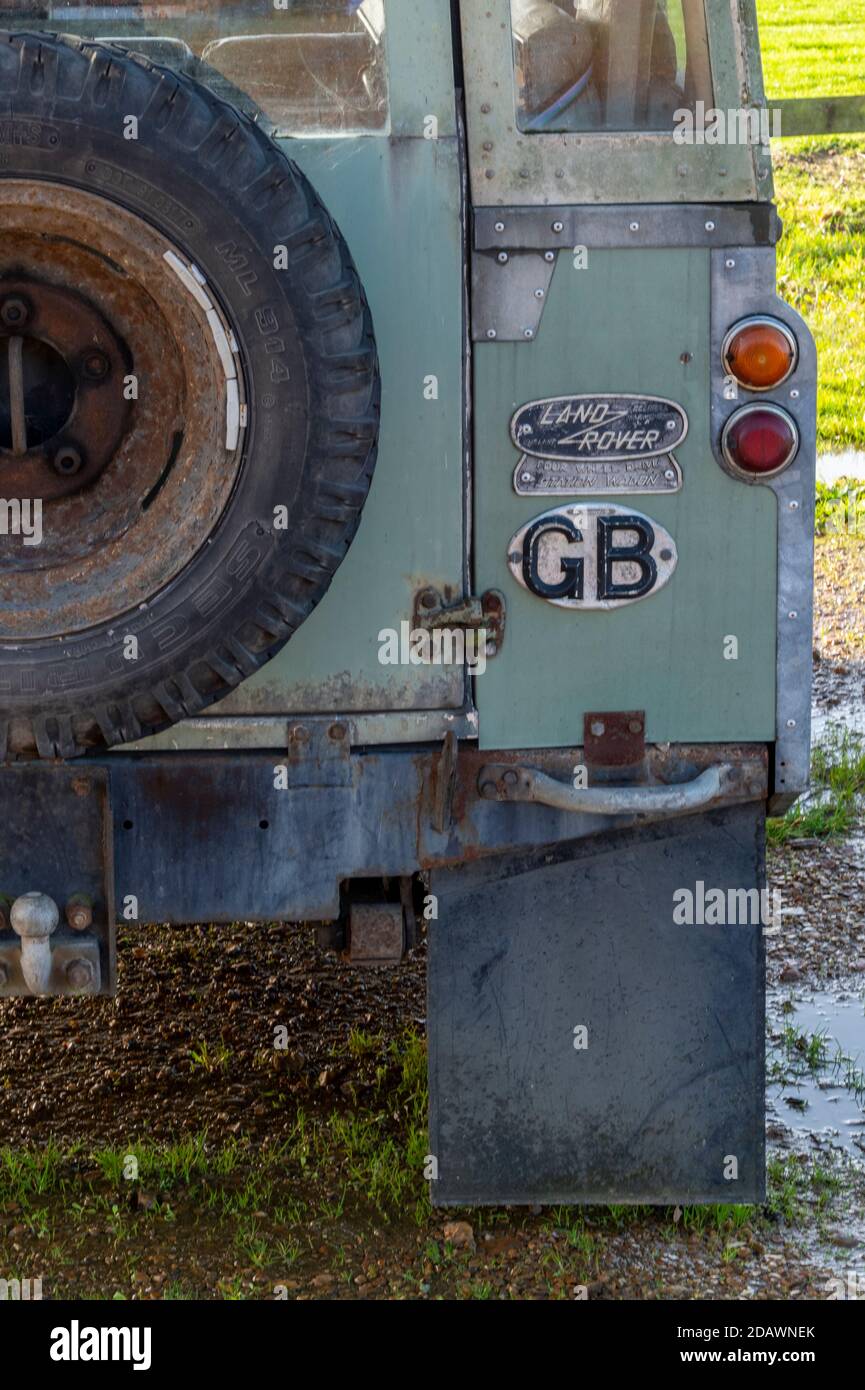 The rear of an old series Land Rover with gb sticker and old fashioned Land Rover badge next to spare wheel carrier Stock Photo