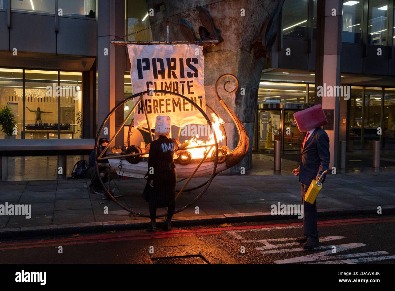 Climate Change activists with Extinction Rebellion set fire to a 'Viking Ship' outside the National Maritime Organisation, a day before the NMO's virtual summit of its Marine Environment Protection Committee, on 15th November 2020, in London, England. Stock Photo
