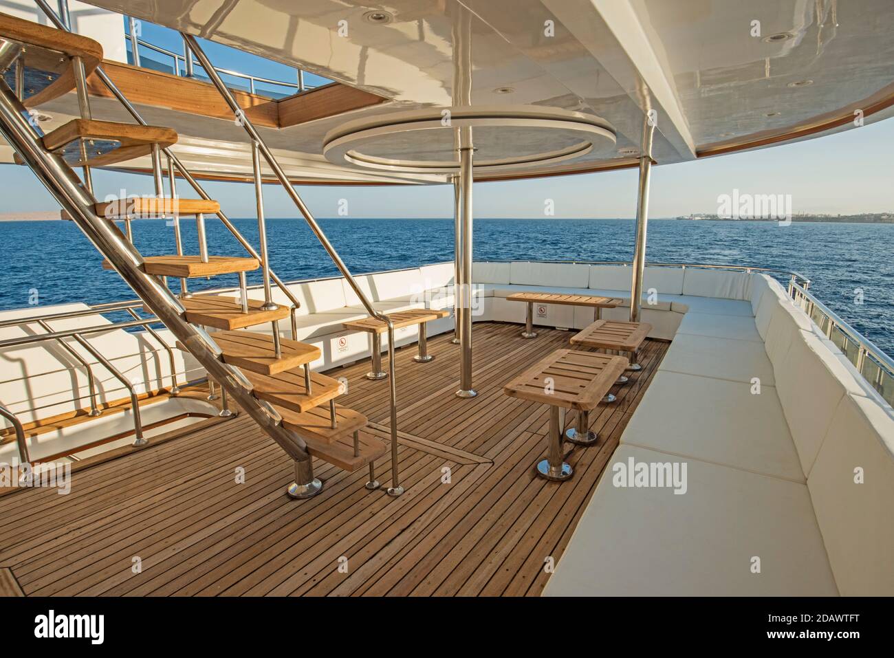 Teak stern wooden deck of a large luxury motor yacht with chairs sofa ...