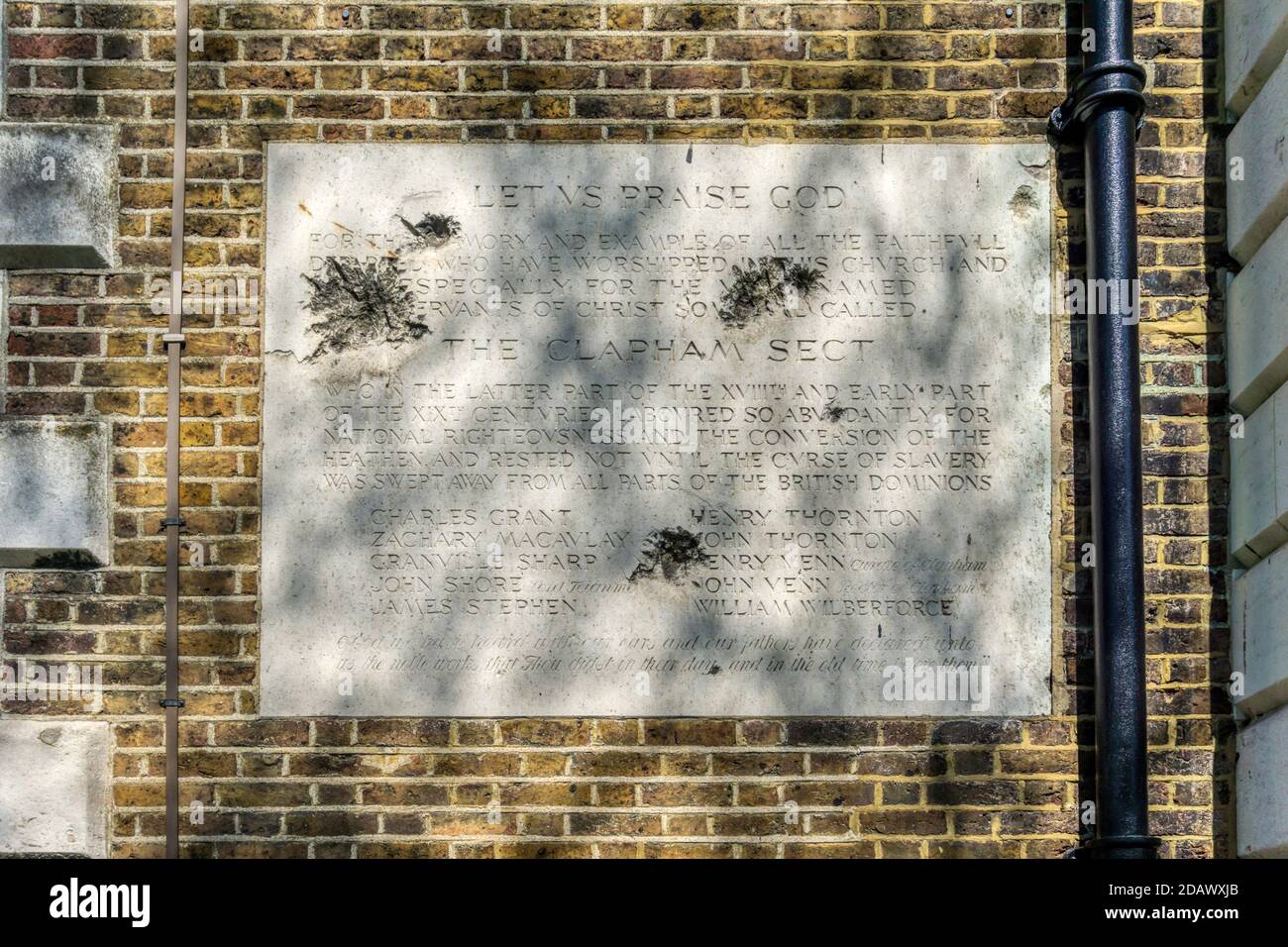 Shrapnel damage from WWII to a plaque commemorating The Clapham Sect anti-slavery campaigners.  On Holy Trinity church, Clapham Common. Stock Photo