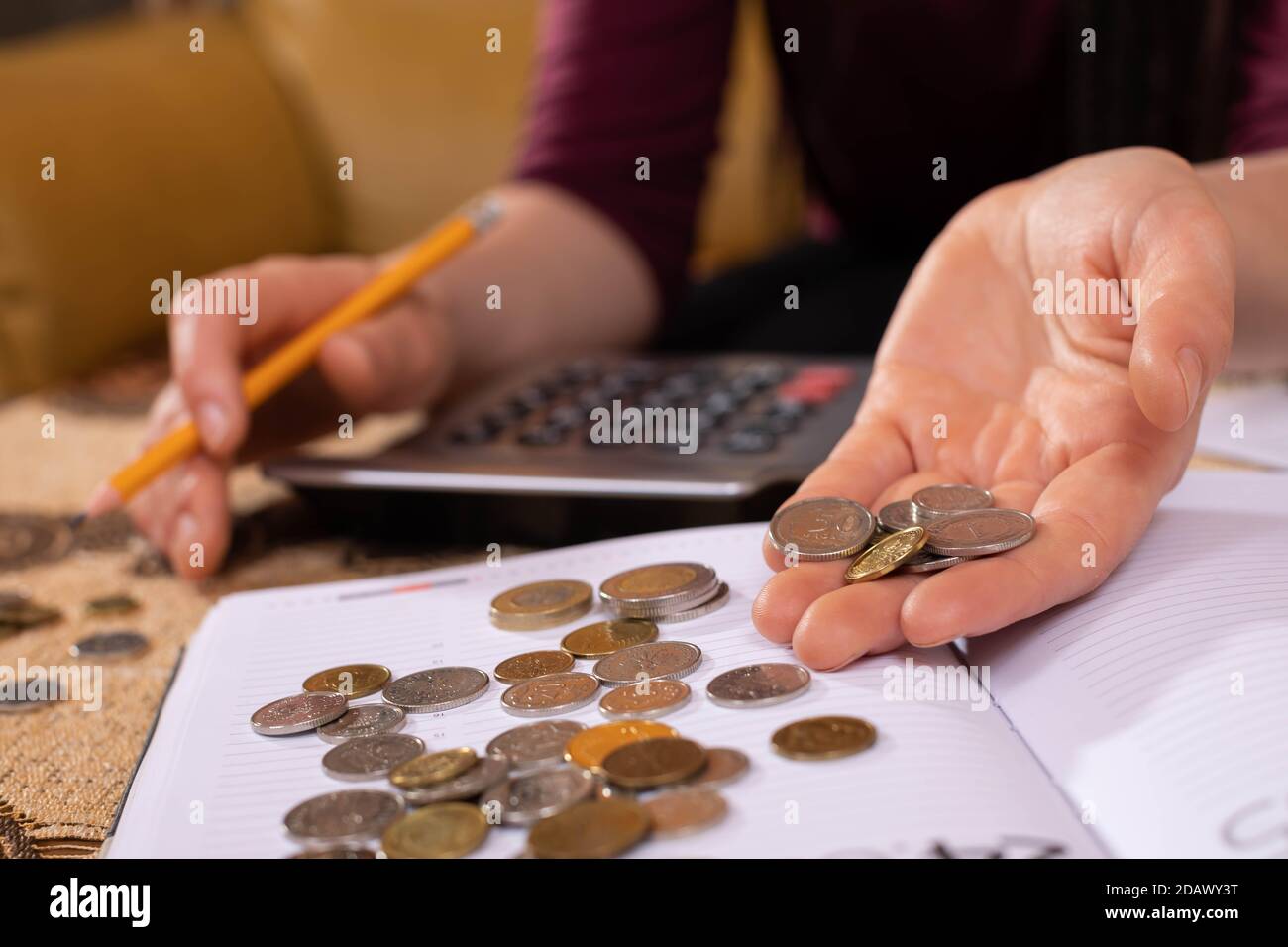 Young teenage girl hands. Scattered coins on a book calendar