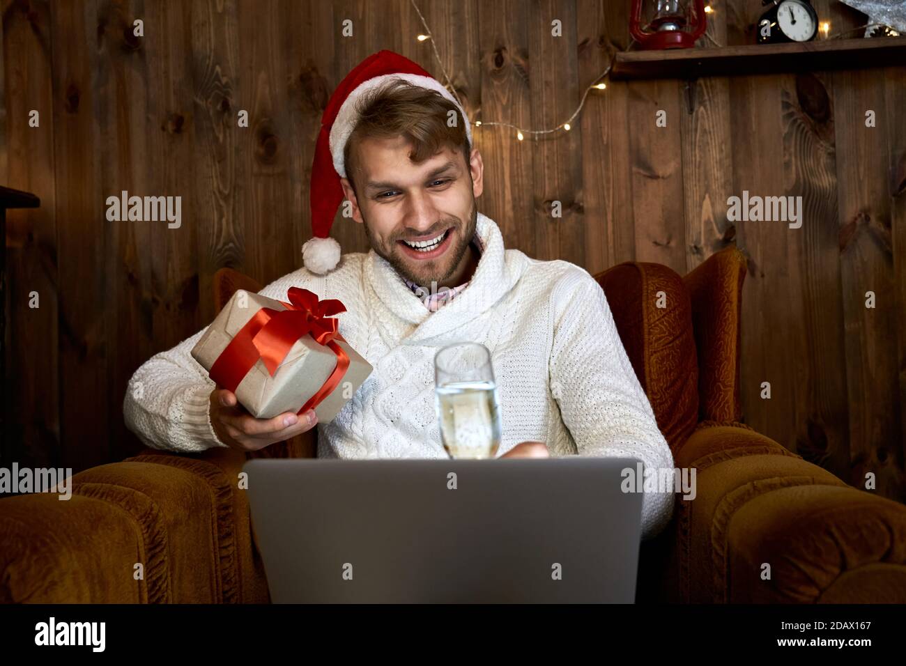 Happy young man celebrating virtual New Year virtual online party using laptop. Stock Photo
