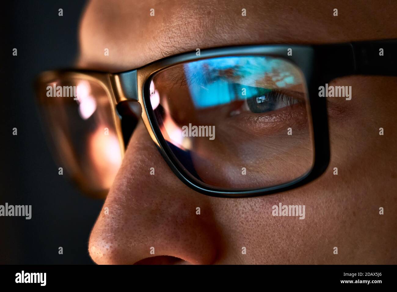 Close up view of focused businessman wear computer glasses looking at pc screen. Stock Photo