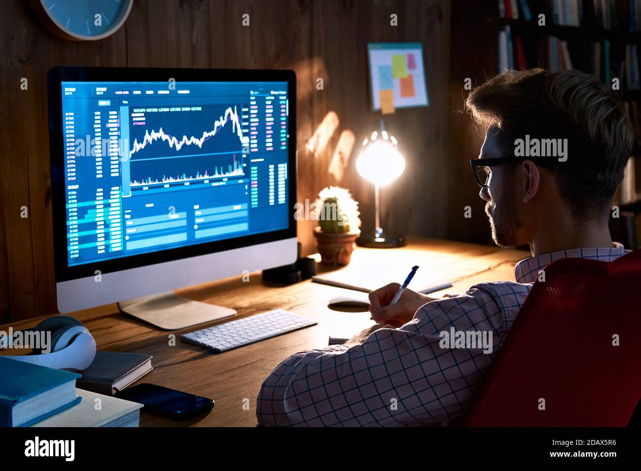 Stock market analyst looking at computer trading online analyzing data. Stock Photo