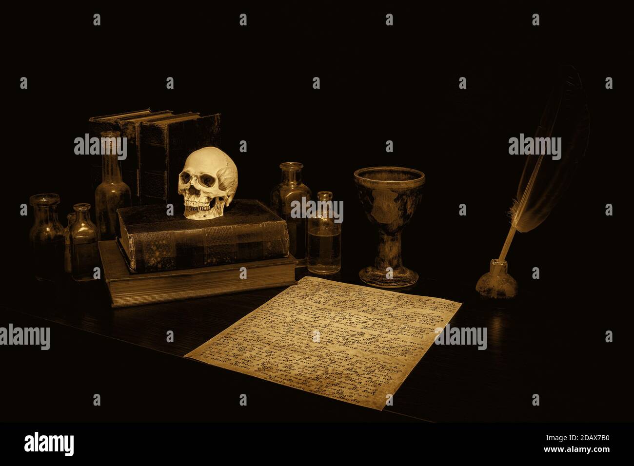 Old spooky desk in sepia, with parchment, feather pen, chalice, books, skull, and bottles. Parchment is arcane runes. Sepia antique atmosphere. Stock Photo