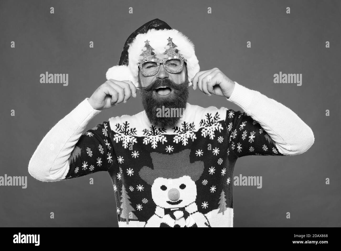 Be fashionable and celebrate. Happy hipster in fashionable santa style. Bearded man twirl fashionable mustache. Holiday celebration. Christmas and new year. Fashionable design for festive holidays. Stock Photo