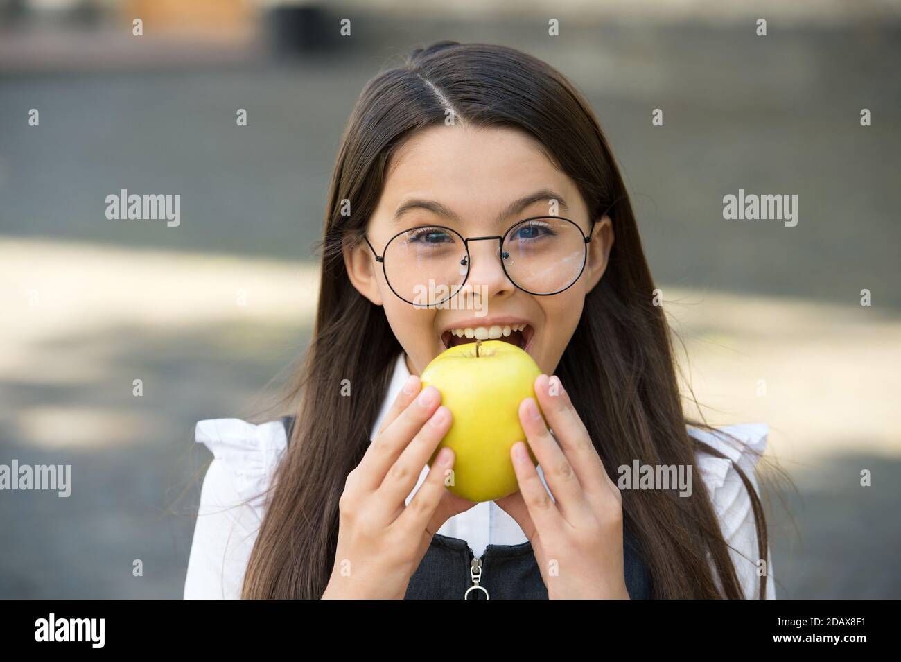 Food for your teeth. Little child bite apple outdoors. School snack