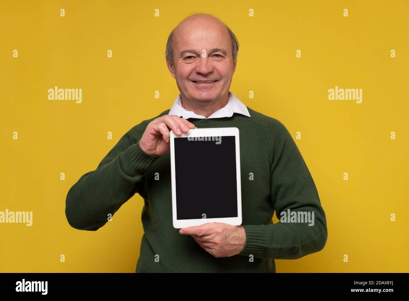 Senior aged middle aged man holding tablet with blank screen Stock Photo