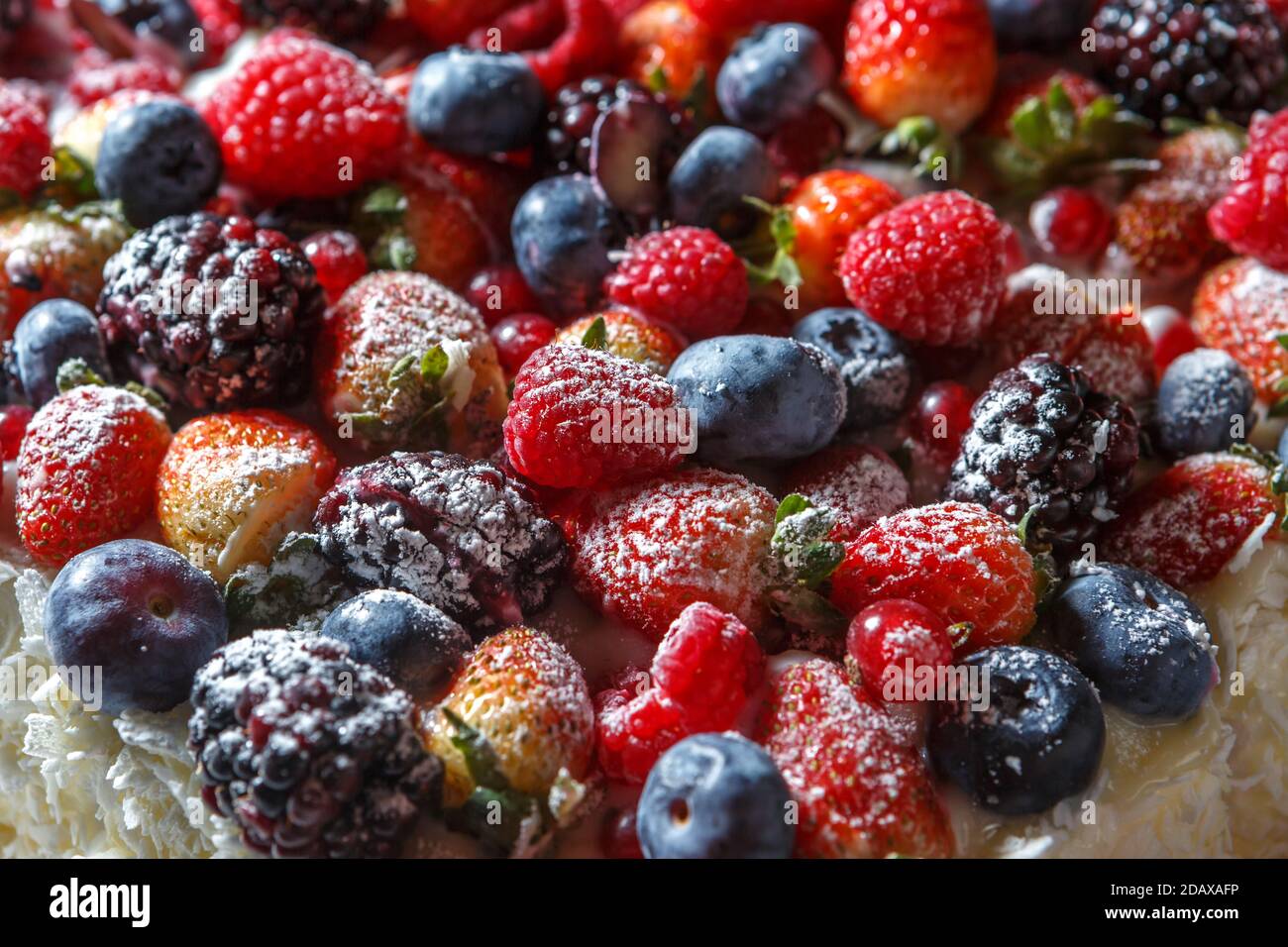 Mix of fresh berries sprinkled with powdered sugar close up Stock Photo