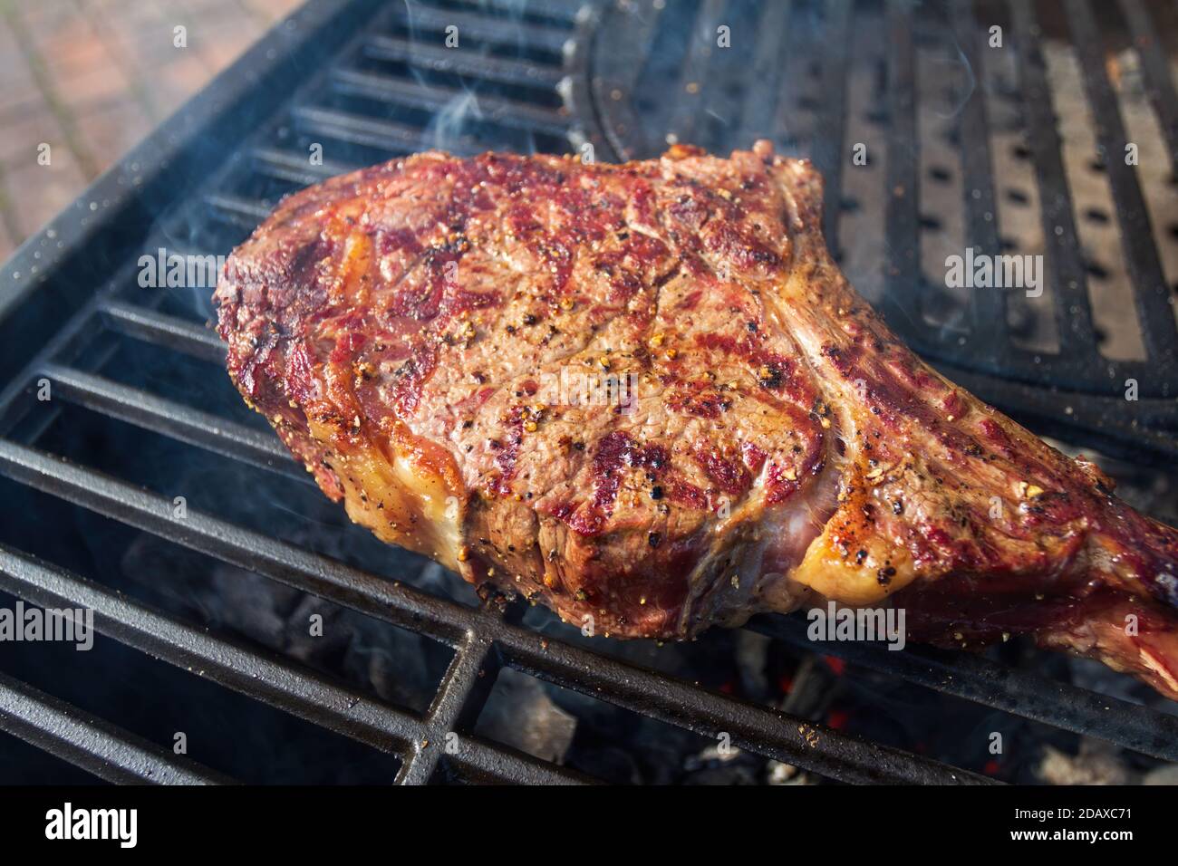 Dry Aged Barbecue Tomahawk Steak on grill Stock Photo