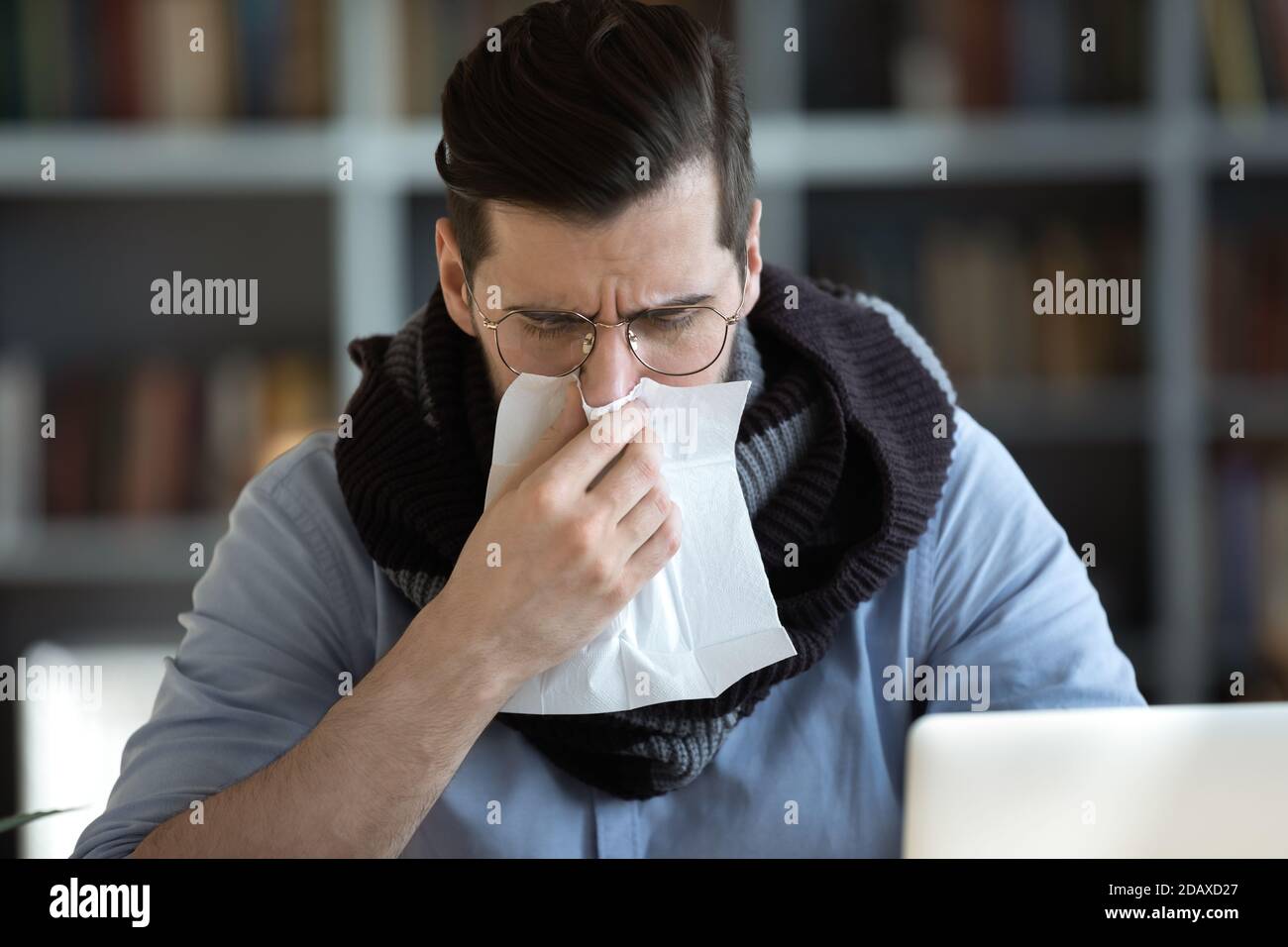 Sick office employee blowing running nose in paper tissue Stock Photo
