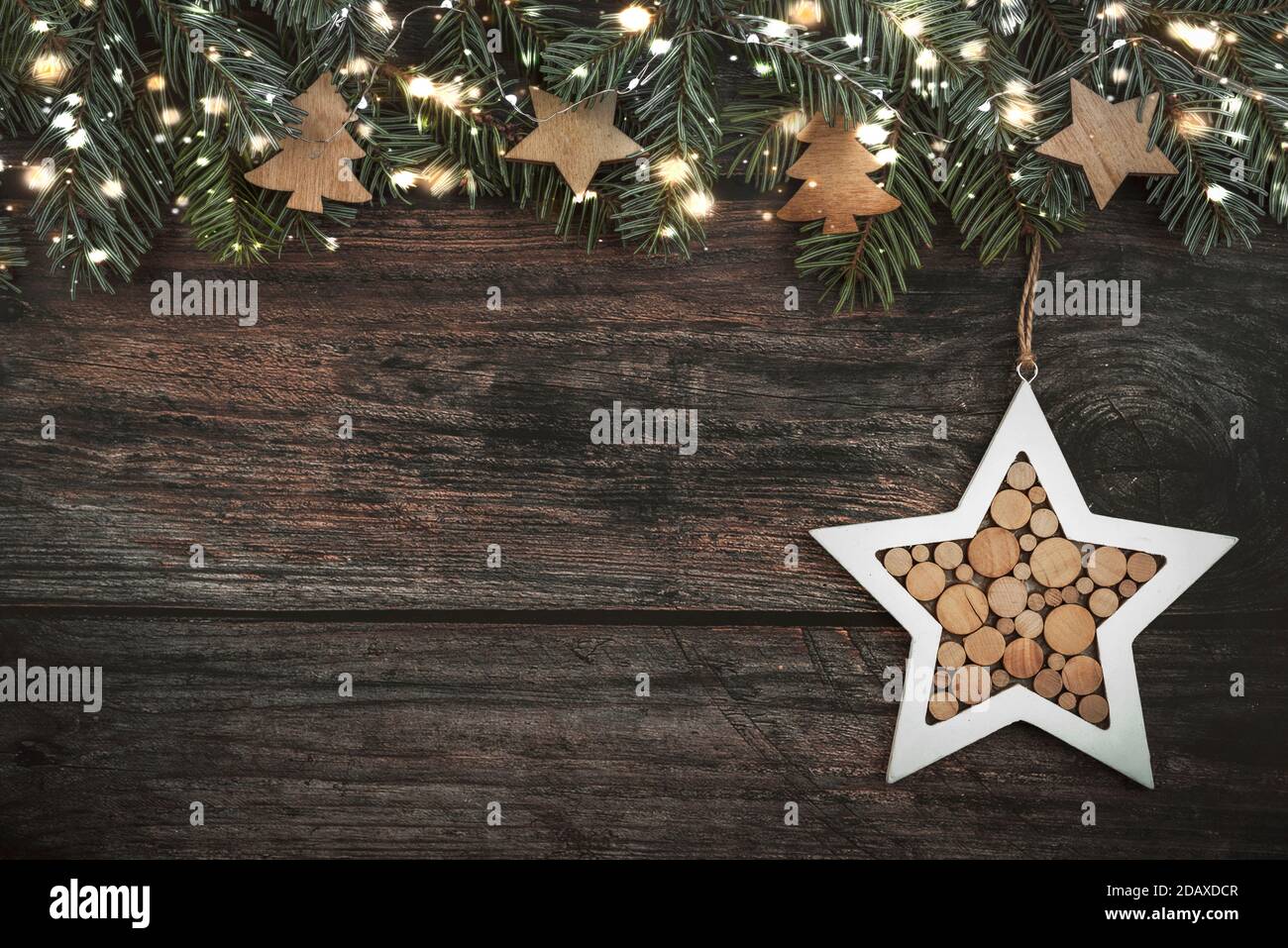 Merry Christmas.Christmas concept background.Christmas tree branches with christmas lights and Christmas star on wood table Stock Photo