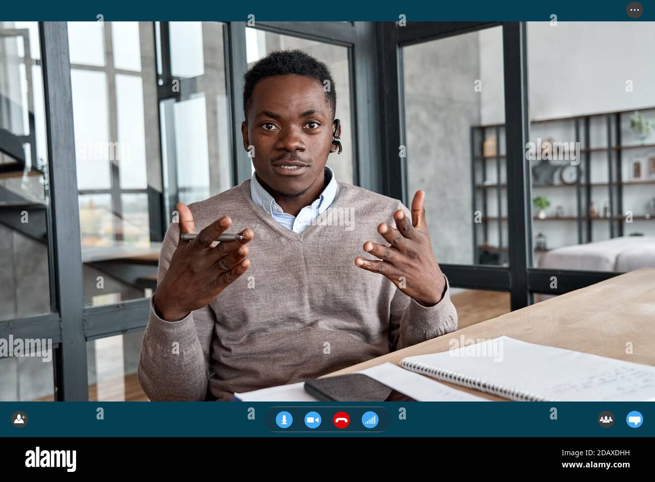 African business man wearing headset talking to camera, web cam view. Stock Photo