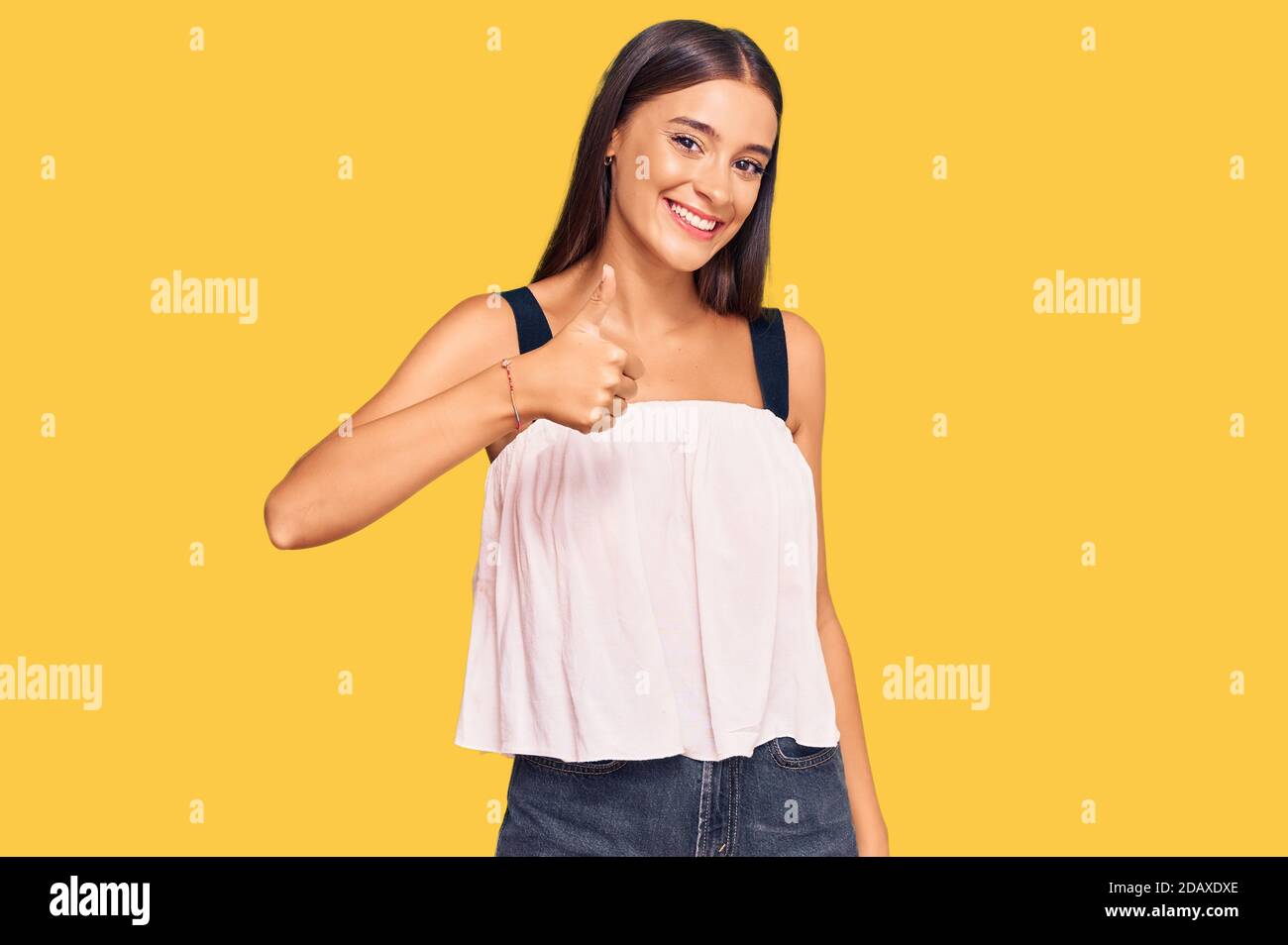 Young hispanic woman wearing casual clothes doing happy thumbs up ...