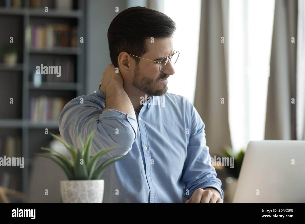 Man sit at workplace desk touch neck feeling pain Stock Photo Alamy