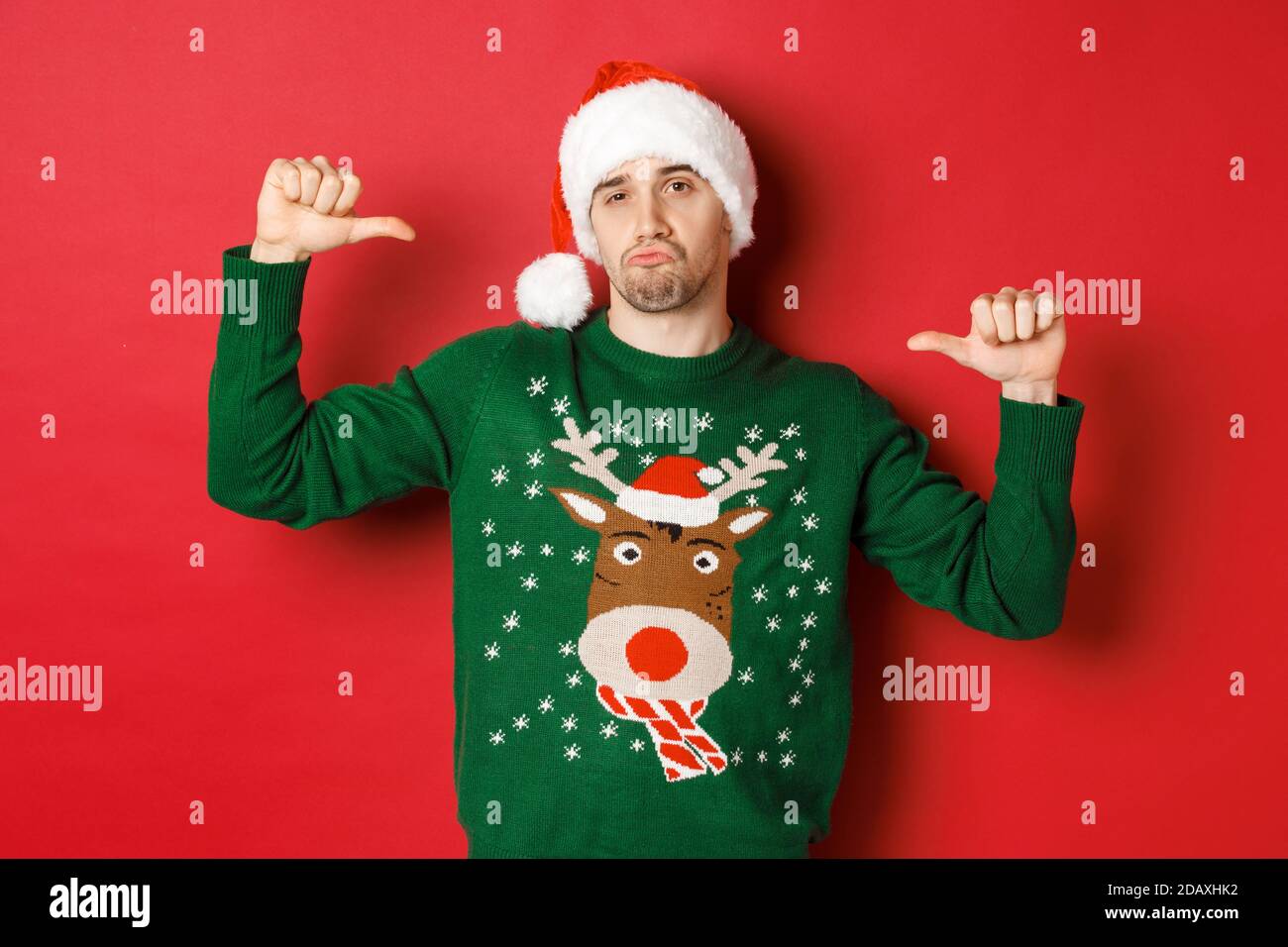 Image of handsome and confident young man in green sweater and santa ...
