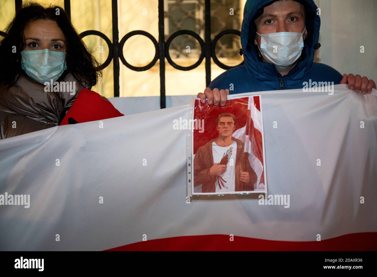 Moscow, Russia. 15th of November, 2020 People hold a white-red-white flag and a portrait of Roman Bondarenko, a Belarusian opposition supporter who died in Minsk, outside the Embassy of the Republic of Belarus in Moscow, Russia Stock Photo