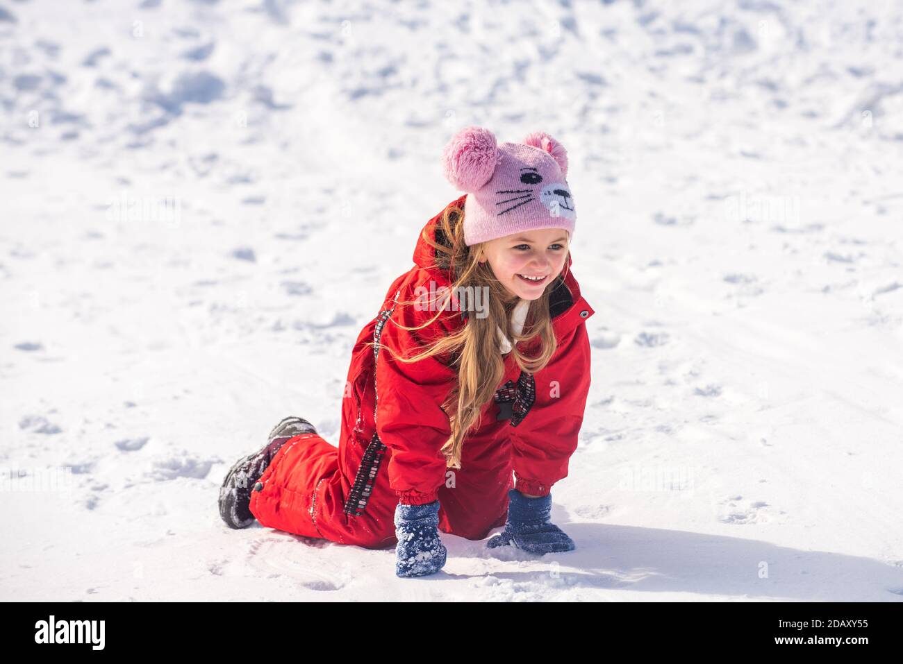 Funny child playing with snow in winter. Little girl in colorful jacket ...