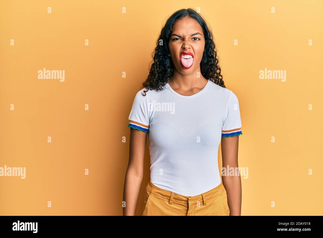 Young african american girl wearing casual clothes sticking tongue out ...