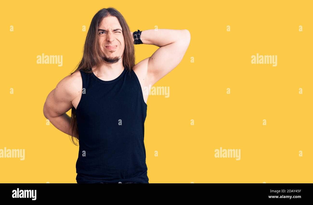 Gothic Injuries Young adult man with long hair wearing goth style with black clothes ...
