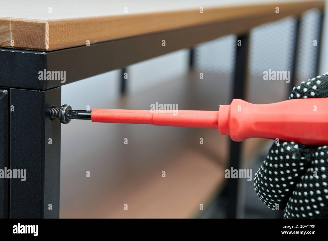 Handyman is tightening bolts while assembling flat pack furniture and