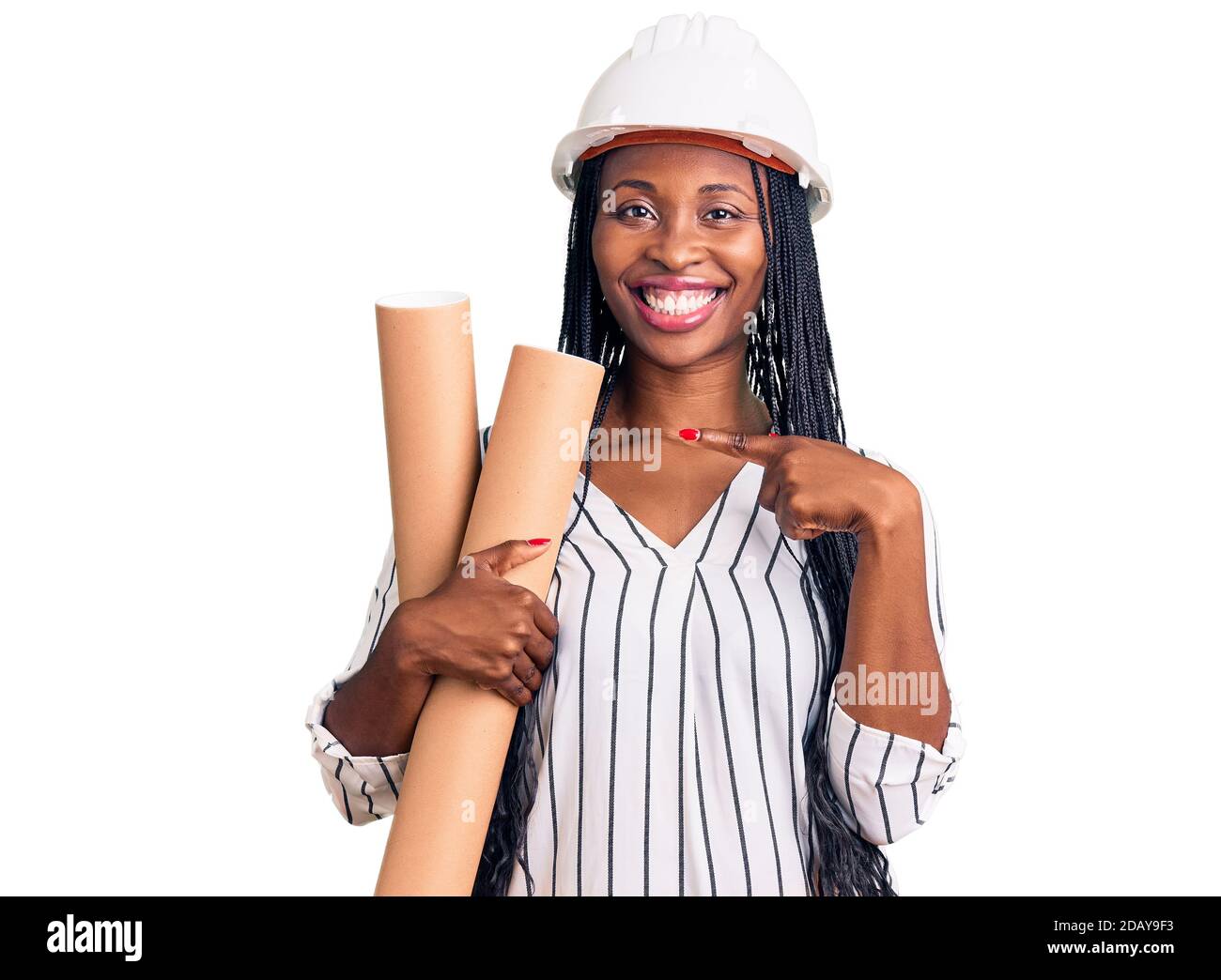 Young african american woman wearing architect hardhat holding blueprints smiling happy pointing with hand and finger Stock Photo