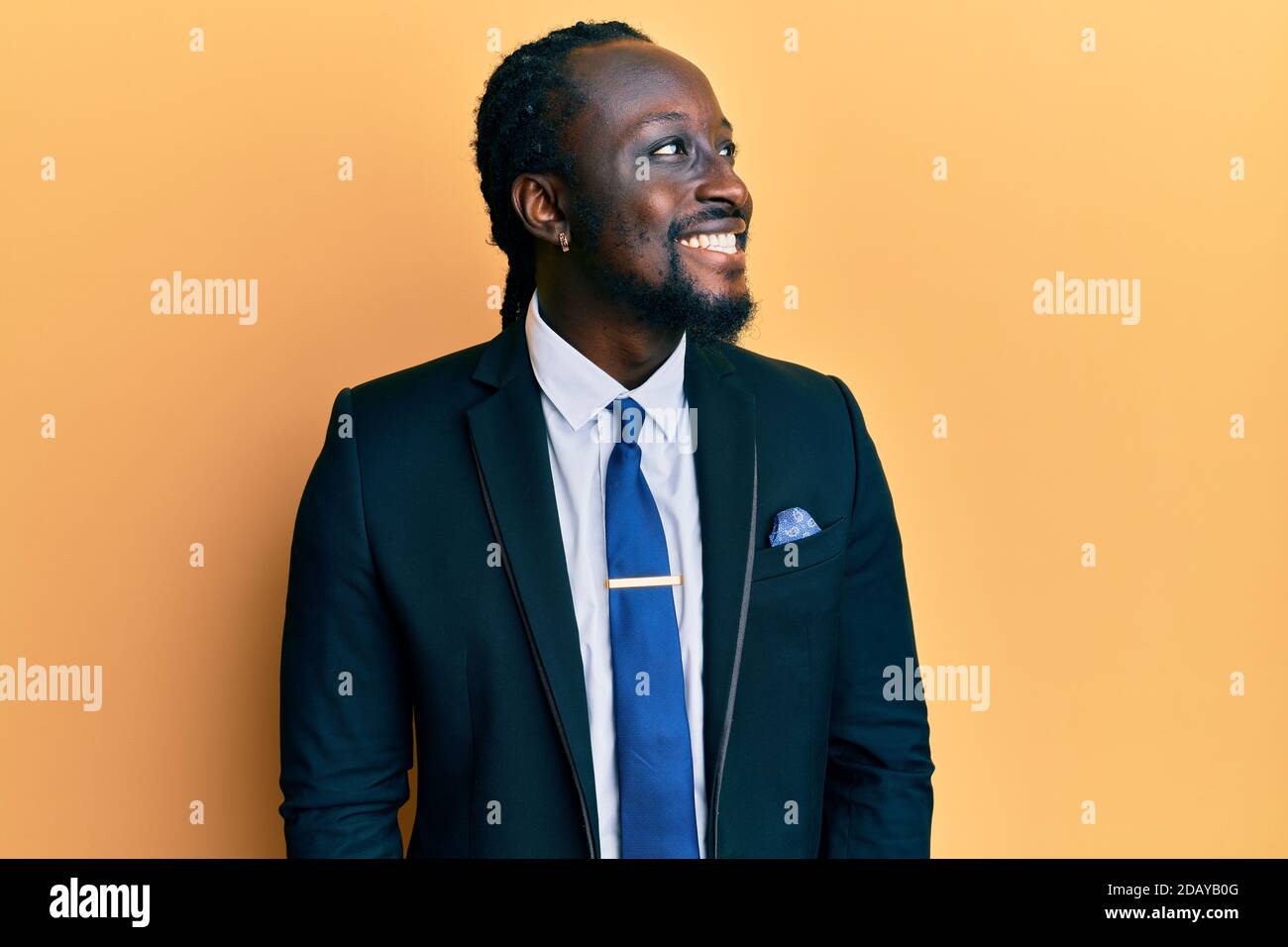 Handsome young black man wearing business suit and tie looking to side ...