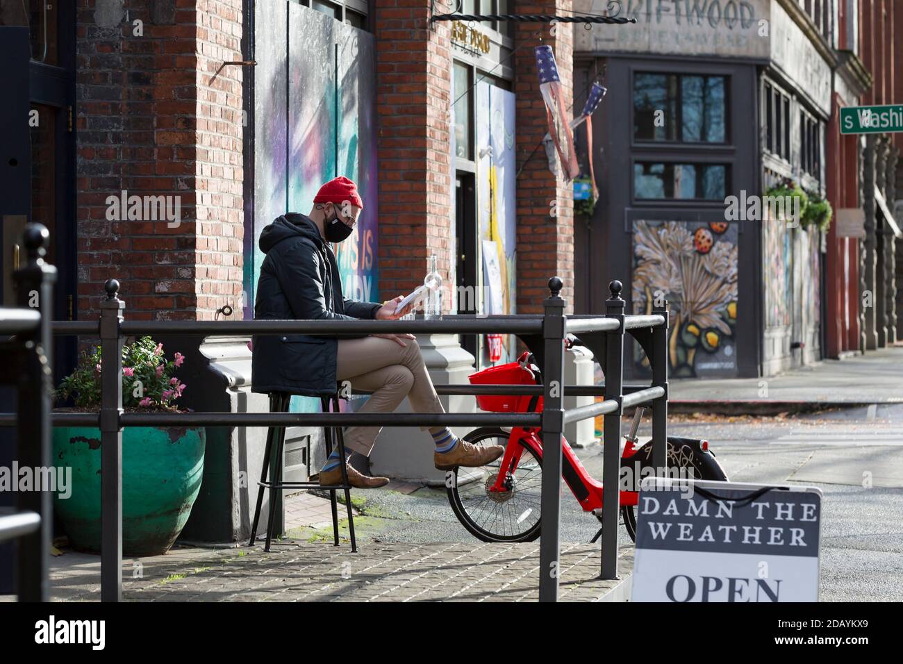 Seattle, Washington, USA. 15th November, 2020. A diner relaxes outdoors at Damn the Weather restaurant in Seattle’s Pioneer Square neighborhood as Washington governor Jay Inslee imposes new statewide restrictions in response to the rapid spread of the COVID-19 virus. Credit: Paul Christian Gordon/Alamy Live News Stock Photo