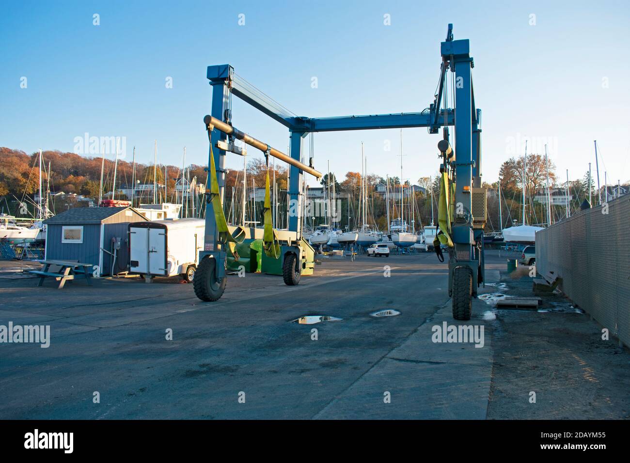 Boat sling at marina with motorboats and sailboats lined up in drydock