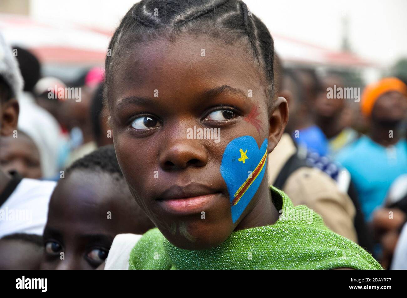 A young girl painted heart-shaped flags on her face to symbolize their love of their country, Democratic Republic of Congo. Stock Photo