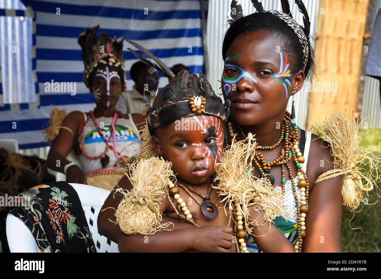 A woman and child, both members of the Matakiyo Group, wear traditional clothes and face paint in Democratic Republic of Congo. Stock Photo