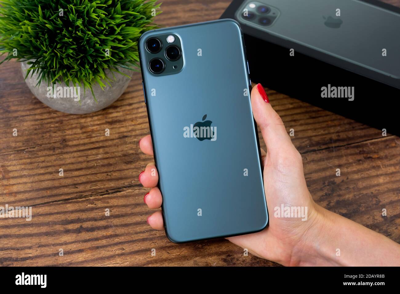 iPhone 11 Pro Max in midnight green color next to its box Stock Photo