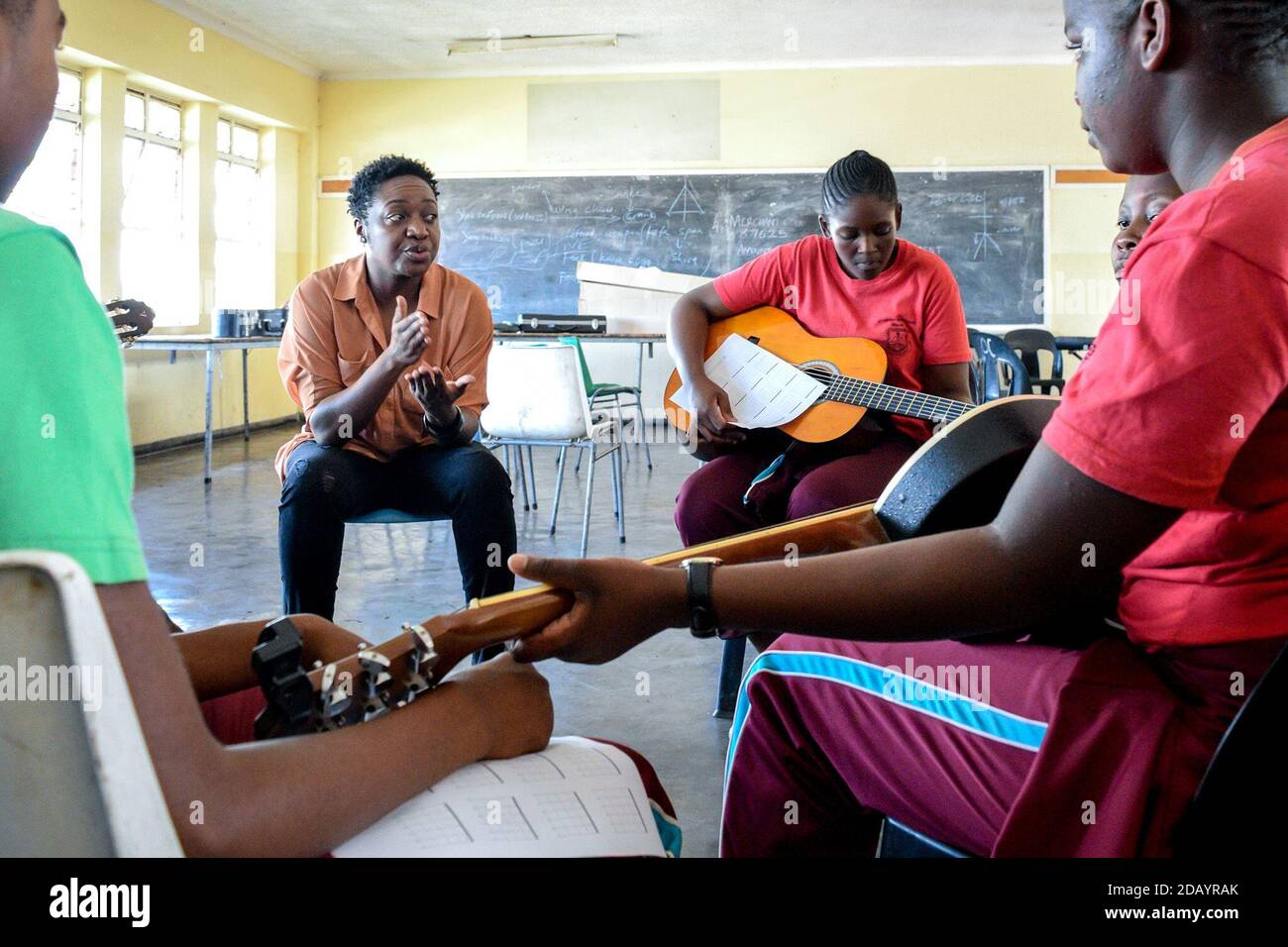 Musician Tariro ne Gitare (left) gives guitar lessons to students at St