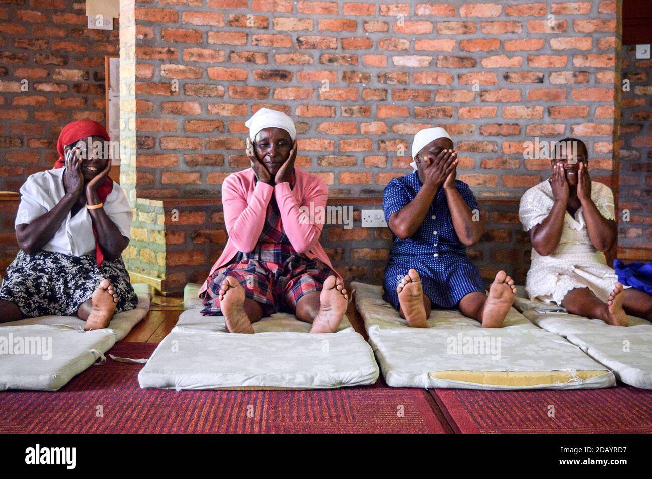Women massage their hands, face and legs as a relaxation technique during Tara Rokpa therapy at the Rokpa Support Network in the Harare suburb of Monavale, Zimbabwe. Stock Photo