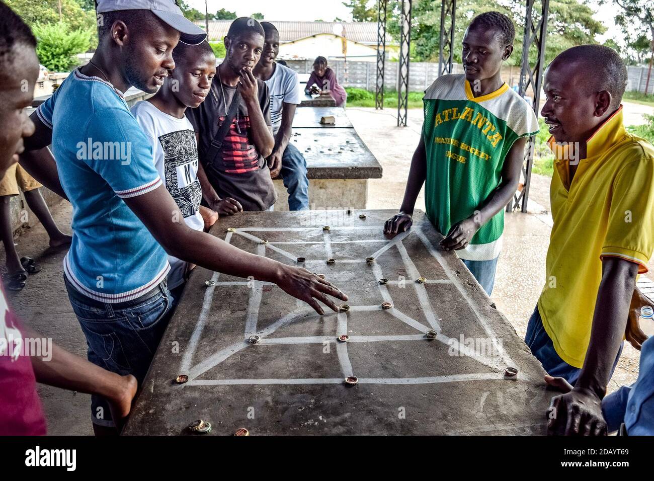 Tatenda Seremwe (second from left) and Tonderai Goreraza (second from right) play Three Make a Line, a game they play on weekends in Mabvuku, Zimbabwe Stock Photo