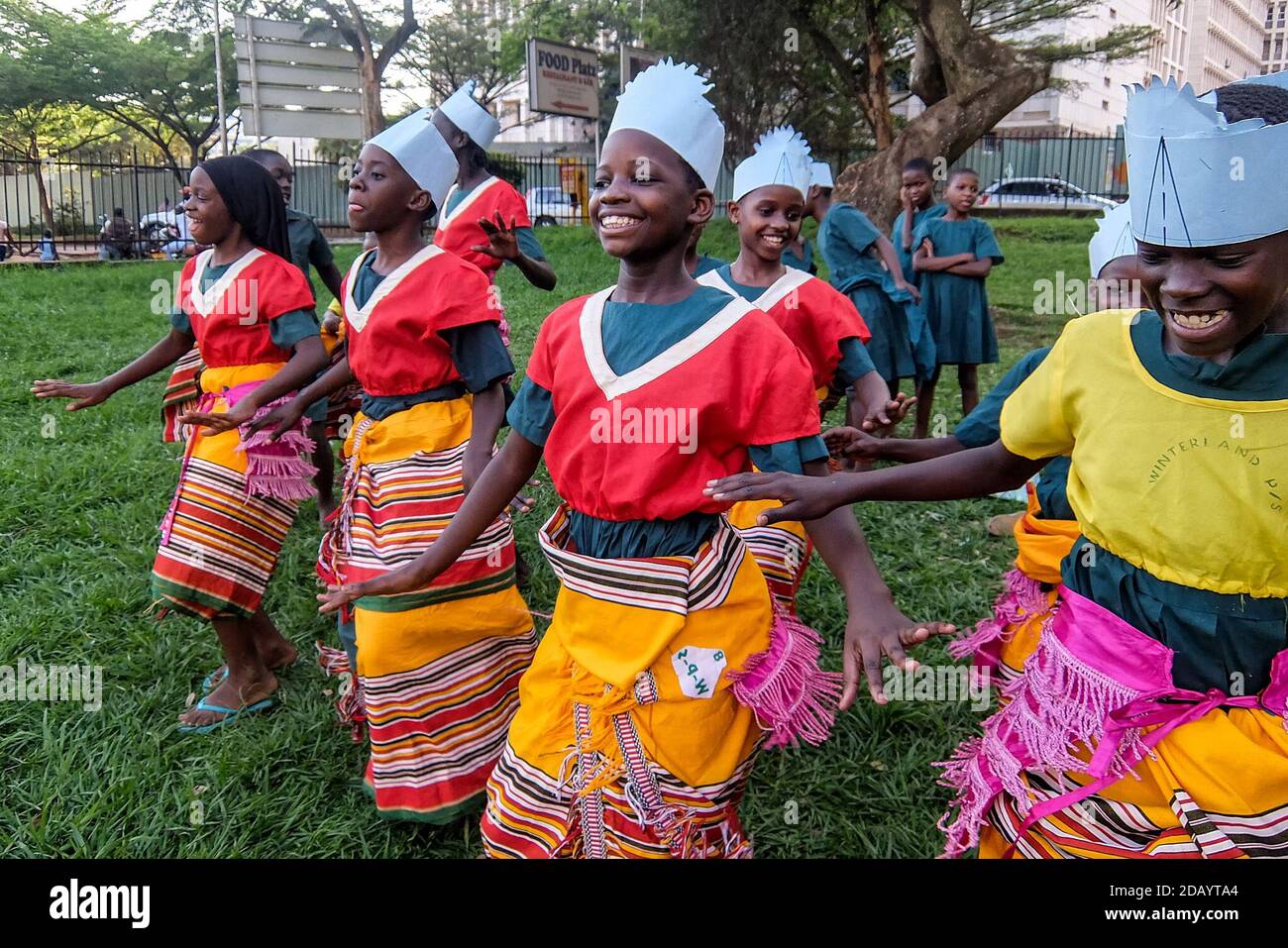 Magdalene Primary School students rehearse a traditional dance called bakisimba at the National Theatre Gardens in Kampala, Uganda, before the premiere of a local film, “The Secrets of a Tourist.” Stock Photo