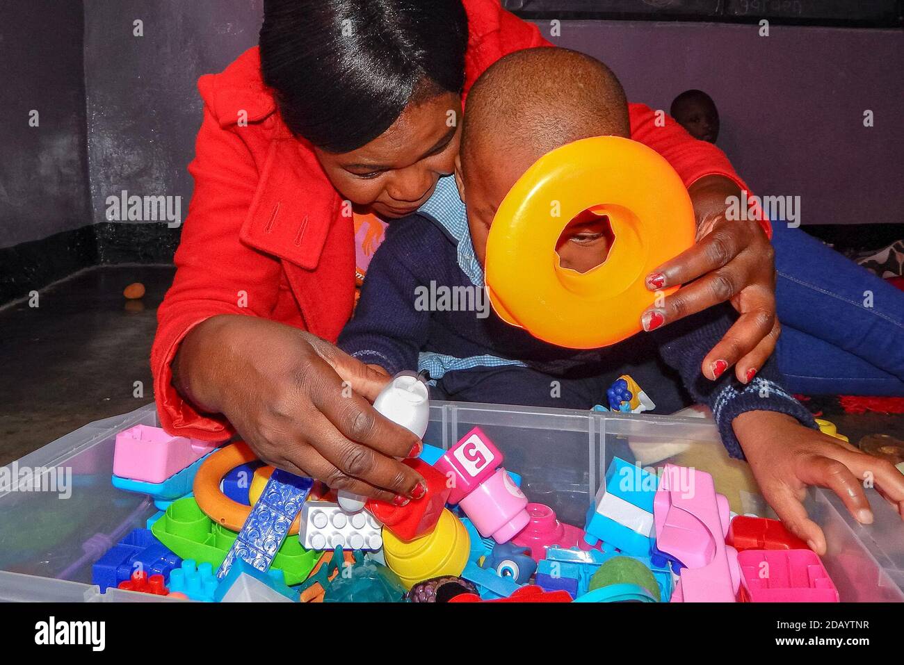 Lebetina Chimbalo, a teacher at Proactive WAYS Academy, plays with a child in Lusaka, Zambia. Stock Photo